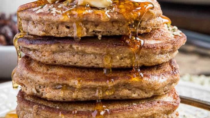 close up stack of paleo carrot cake pancakes with honey being drizzled on top