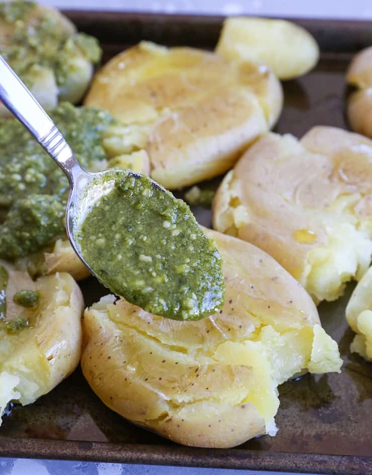 Smashed potatoes with pesto drizzled on top
