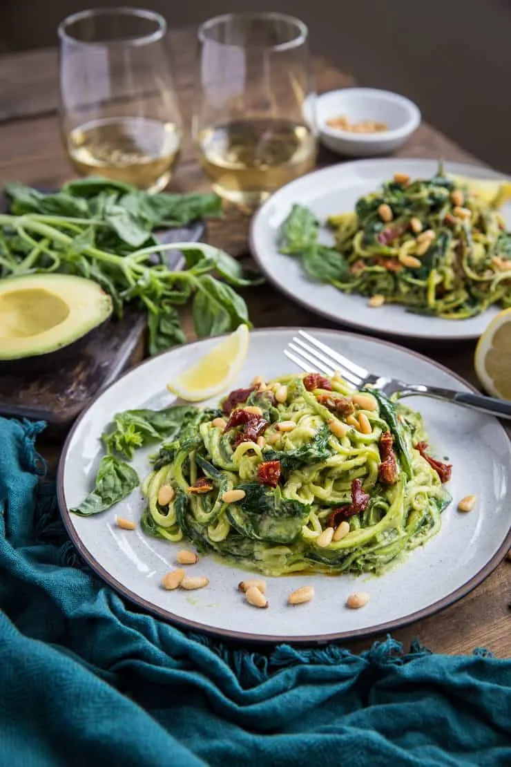 Avocado Pesto Zoodles with Sun-Dried Tomatoes, Spinach, and Pine Nuts - this gluten-free, vegan, paleo dinner recipe only requires about 30 minutes to make.