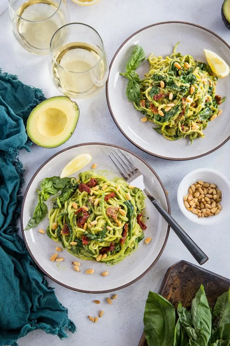 Avocado Pesto Zoodles with Sun-Dried Tomatoes, Spinach, and Pine Nuts. A healthy vegan and paleo dinner recipe that only takes 30 minutes to make