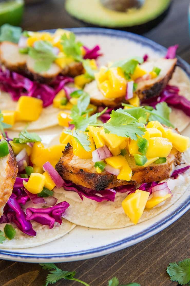 Grilled Chicken Tacos with Mango Salsa, cabbage slaw, and chipotle sour cream - a fresh, vibrant, and unique take on tacos!