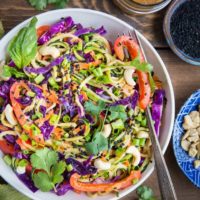 Bowl of zucchini noodles with fresh veggies and sauce.