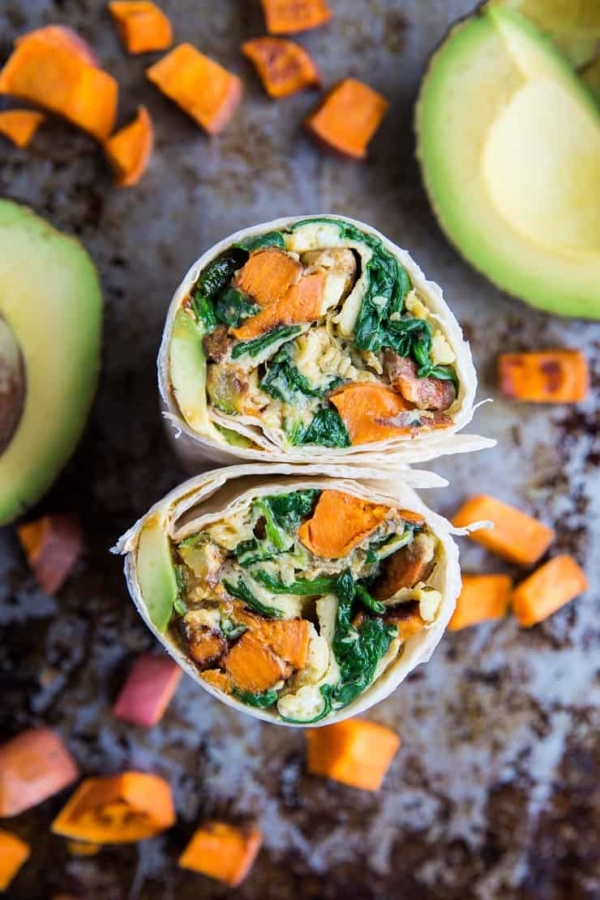 Breakfast burrito sliced in half so you can see the inside.