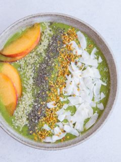 Ginger Peach Smoothie Bowl made banana-free with cauliflower and orange juice. Topped with flaked coconut, bee pollen, chia seeds, hemp seeds and peaches for a real good time. Paleo and delicious! | TheRoastedRoot.net