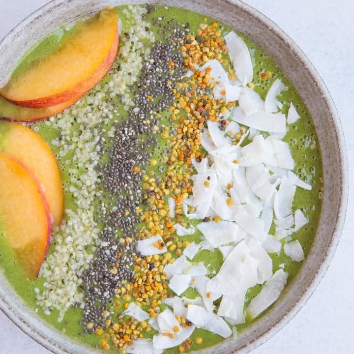 Ginger Peach Smoothie Bowl made banana-free with cauliflower and orange juice. Topped with flaked coconut, bee pollen, chia seeds, hemp seeds and peaches for a real good time. Paleo and delicious! | TheRoastedRoot.net