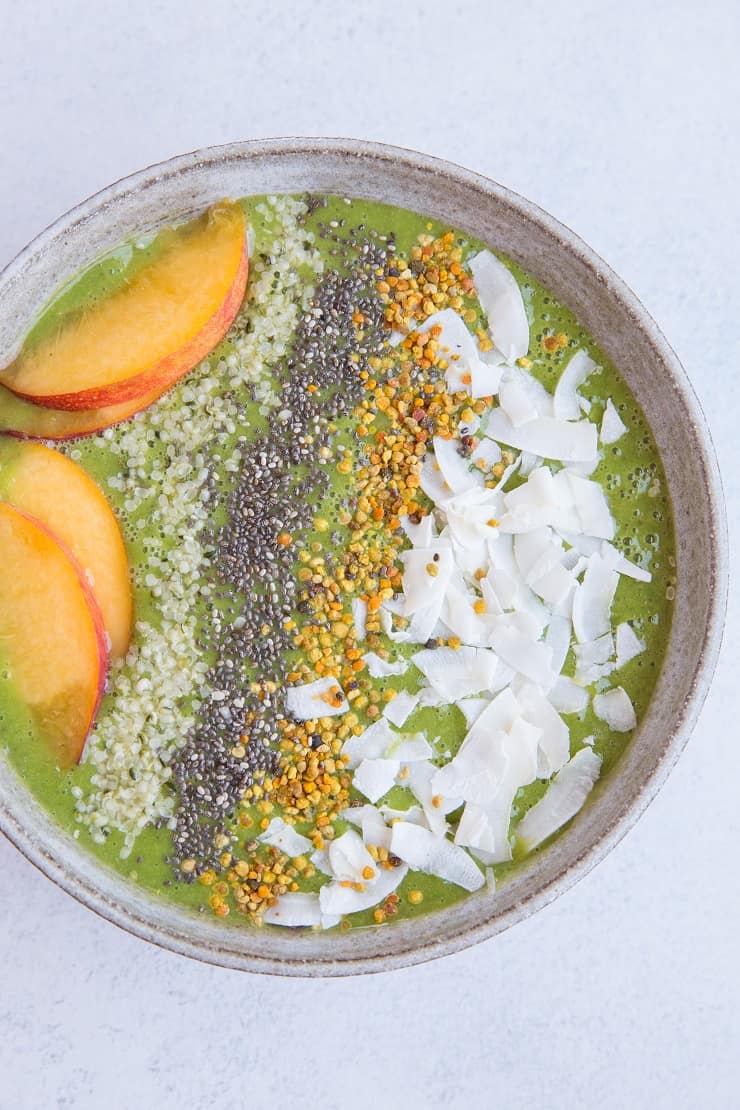 Ginger Peach Smoothie Bowl made banana-free with cauliflower and orange juice. Topped with flaked coconut, bee pollen, chia seeds, hemp seeds and peaches for a real good time. Paleo and delicious! | TheRoastedRoot.net