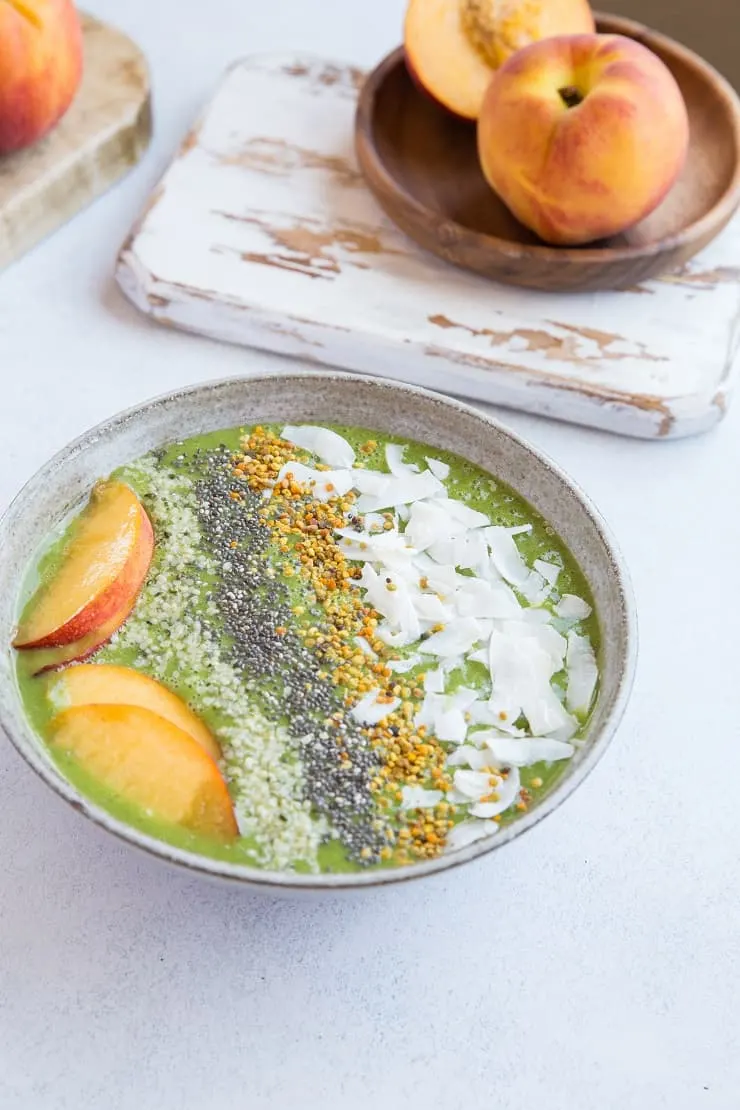 Ginger Peach Smoothie Bowl made banana-free with cauliflower and orange juice. Topped with flaked coconut, bee pollen, chia seeds, hemp seeds and peaches for a real good time. Paleo and delicious! | TheRoastedRoot.net