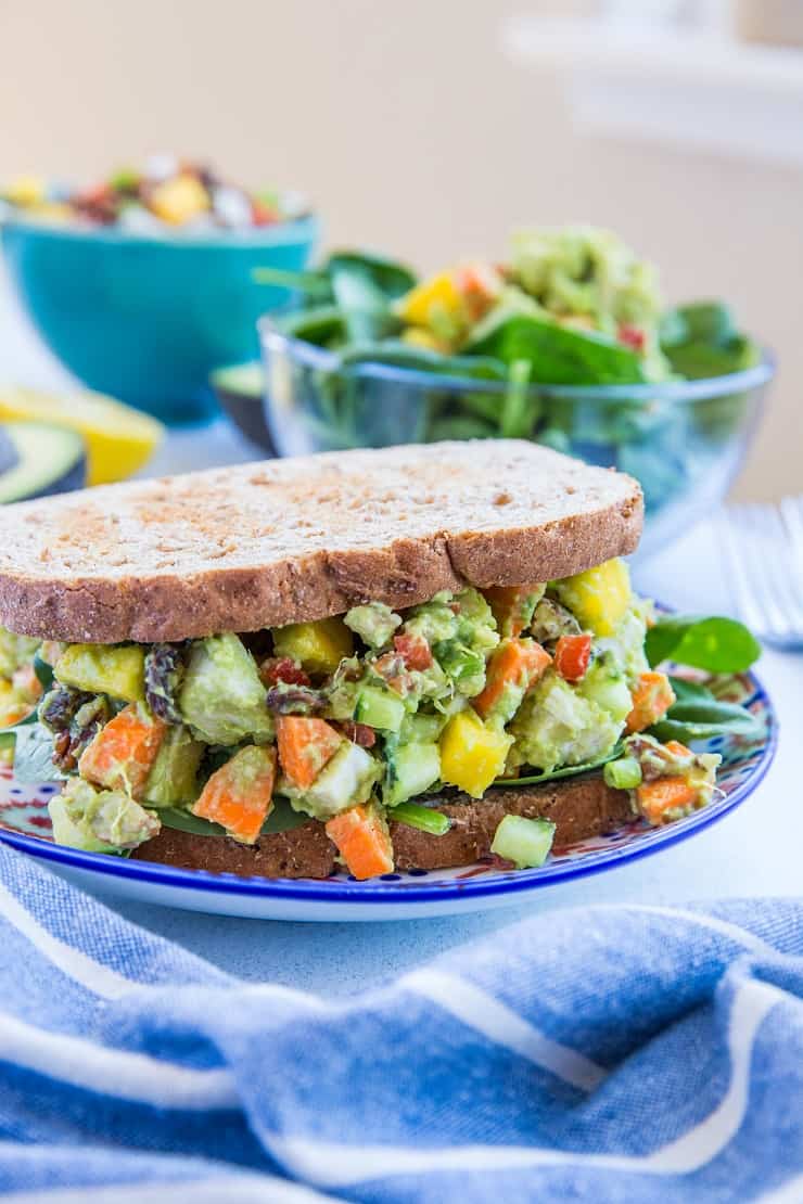 Mayo-Free Mango Avocado Chicken Salad - a healthier chicken salad recipe with carrots, cucumber, green onion, bell pepper, raisins, and pecans. Serve it up on toasted bread as a sandwich or on a green salad!