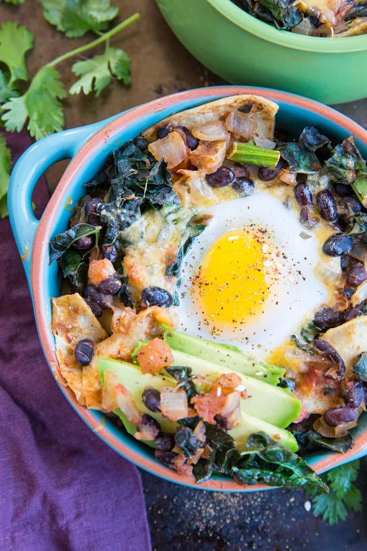 Baked Huevos Rancheros - a unique spin on the traditional Mexican breakfast with black beans, corn tortillas, salsa, avocado, kale, and cheese