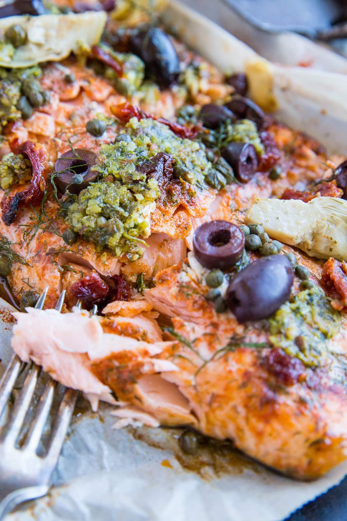 Mediterranean Salmon in Parchment Paper - paleo, keto, low-carb, amazingly flavorful dinner recipe! This salmon with pesto, kalamata olives, capers, sun-dried tomatoes, and artichoke hearts is an epic crowd pleaser!