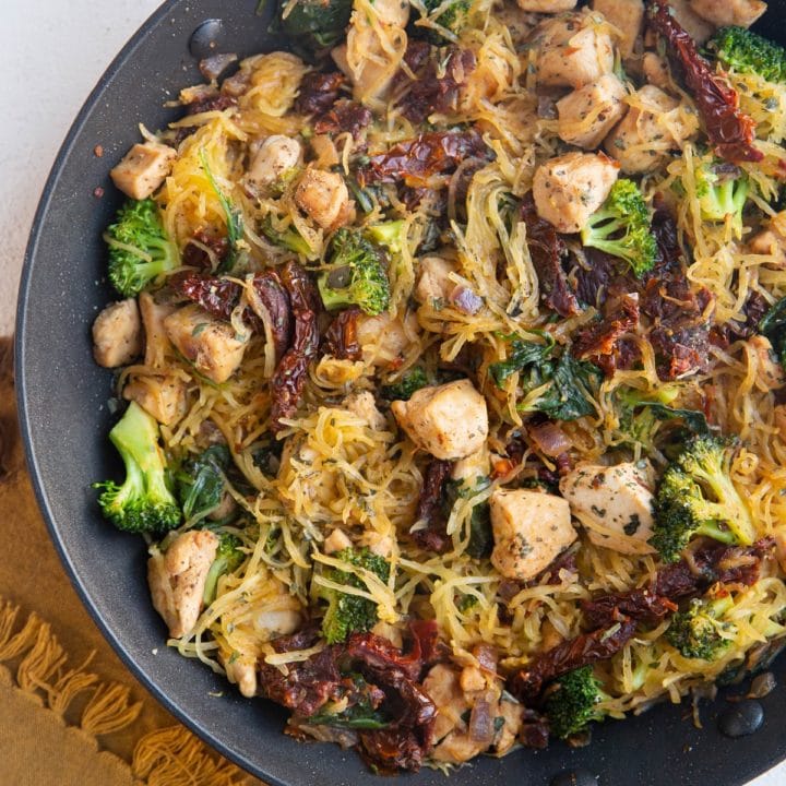 Large skillet with spaghetti squash, chicken, sun-dried tomatoes, broccoli, spinach, and feta cheese.