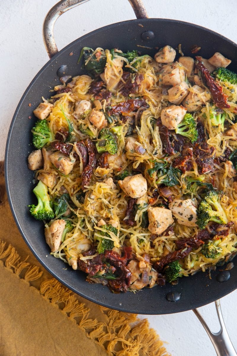 Large skillet with spaghetti squash, chicken, sun-dried tomatoes, broccoli, spinach, and feta cheese.