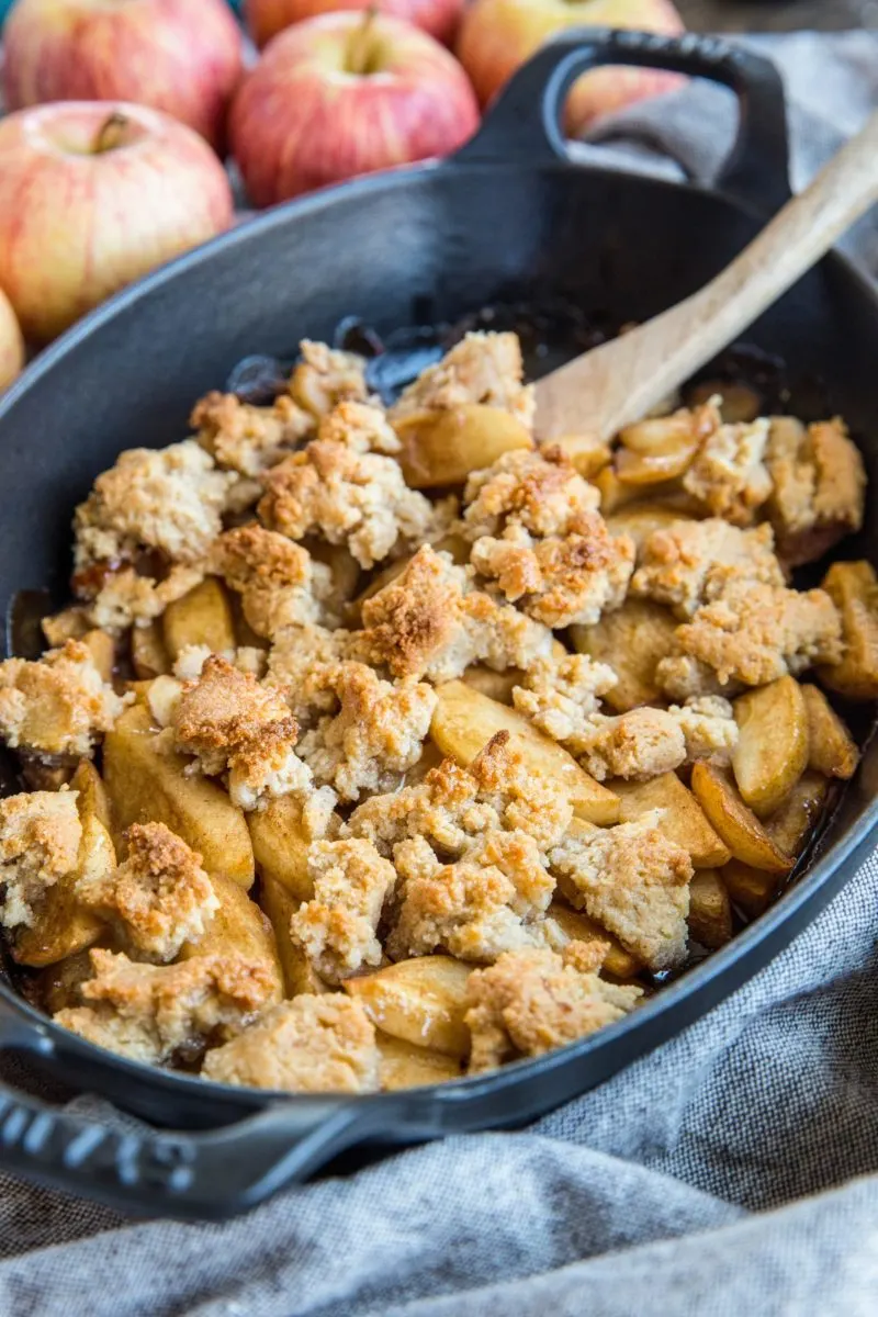 Cast iron casserole dish with grain-free apple crisp inside - fresh out of the oven.