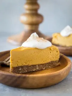 Close up image of two wooden plates of pumpkin cheesecake
