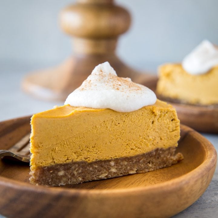 Close up image of two wooden plates of pumpkin cheesecake