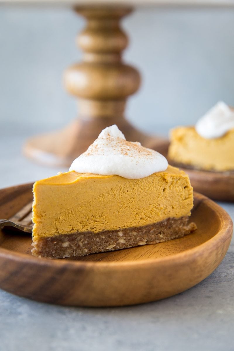 Close up image of two wooden plates of pumpkin cheesecake