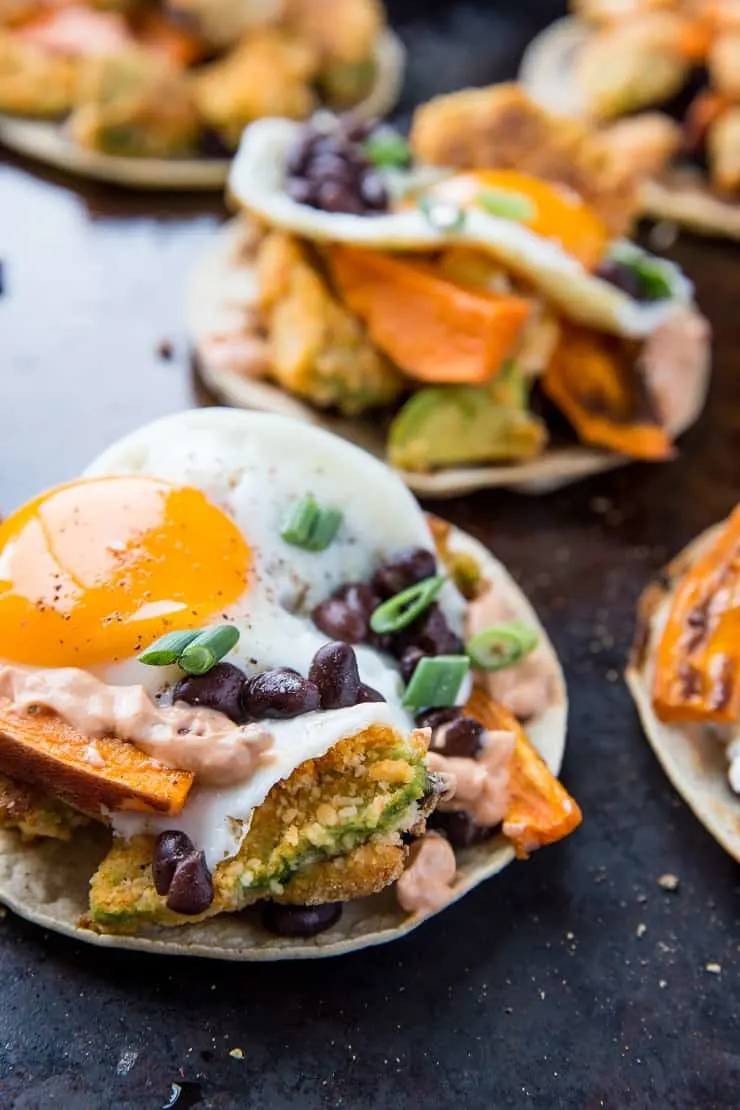 Crispy Avocado Breakfast Tacos with roasted sweet potato, cauliflower, black beans, eggs, and chipotle sauce. A healthy brunch recipe | TheRoastedRoot.net #glutenfree #breakfast