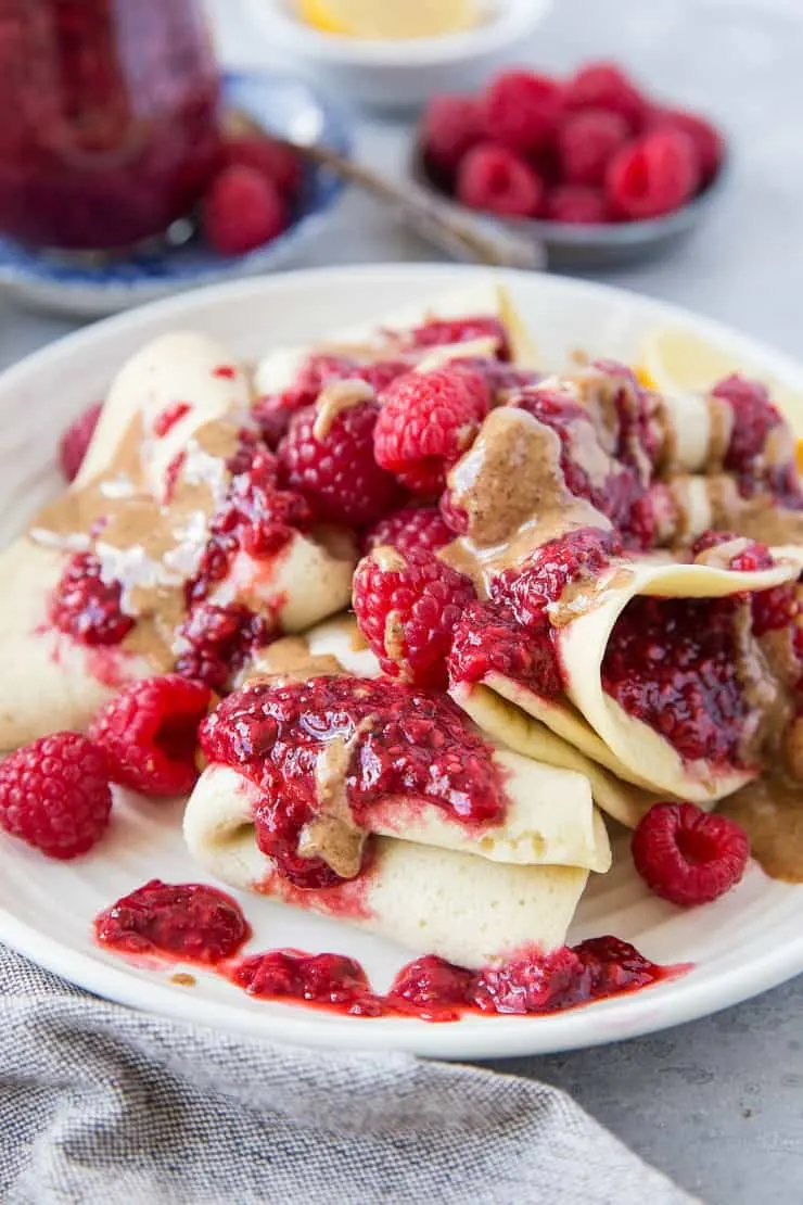 Grain-Free Paleo Crepes made with almond flour topped with almond butter and raspberry chia jam - a healthy and delicious breakfast | TheRoastedRoot.net #glutenfree #dairyfree