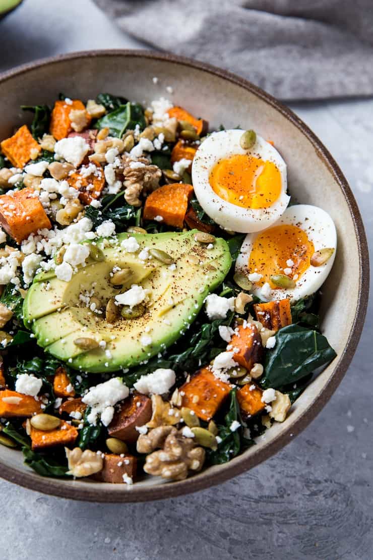 Roasted Sweet Potato Kale Salad with Avocado, Jammy Egg, Pumpkin Seeds, and Walnuts. A filling and nutritious dinner salad | TheRoastedRoot.net