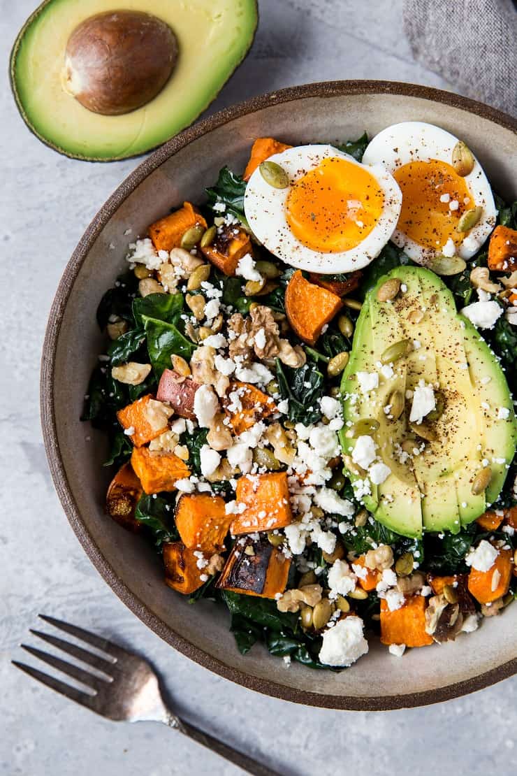 Roasted Sweet Potato Kale Salad with Avocado, Jammy Egg, Pumpkin Seeds, and Walnuts. A filling and nutritious dinner salad | TheRoastedRoot.net