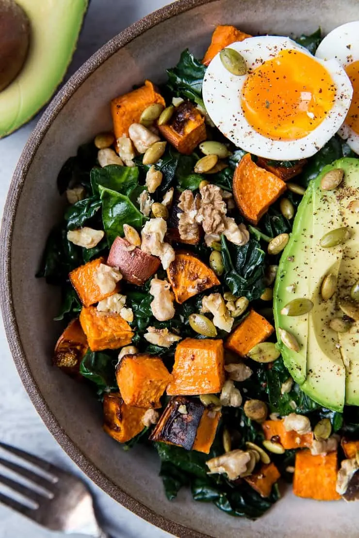 Roasted Sweet Potato Kale Salad with Avocado, Jammy Egg, Pumpkin Seeds, and Walnuts. A filling and nutritious dinner salad | TheRoastedRoot.net