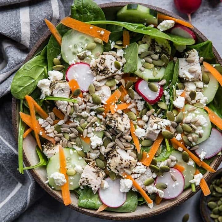 Lemon Herb Baked Chicken Spinach Salad with pumpkin seeds, radishes, cucumbers, feta, and carrots - an easy healthy Low-FODMAP salad recipe | TheRoastedRoot.net