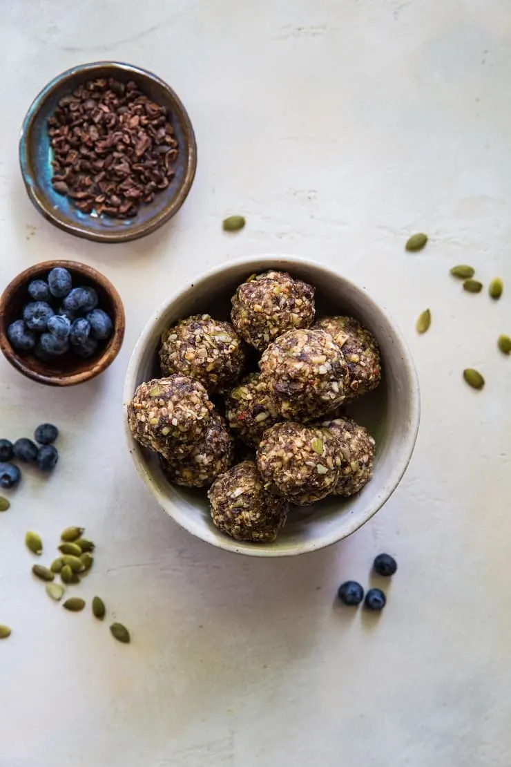 Superfood Blueberry Dark Chocolate Energy Balls made with walnuts, almonds, dates, flax seed oil, and more! A healthy snack recipe | TheRoastedRoot.net #paleo #vegan #healthy