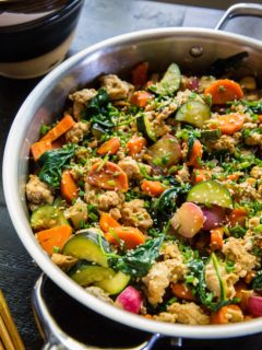 Stainless steel skillet at an angle, filled with ground turkey and vegetables.