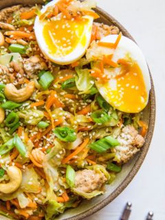 close up egg roll in a bowl with chop sticks to the side.