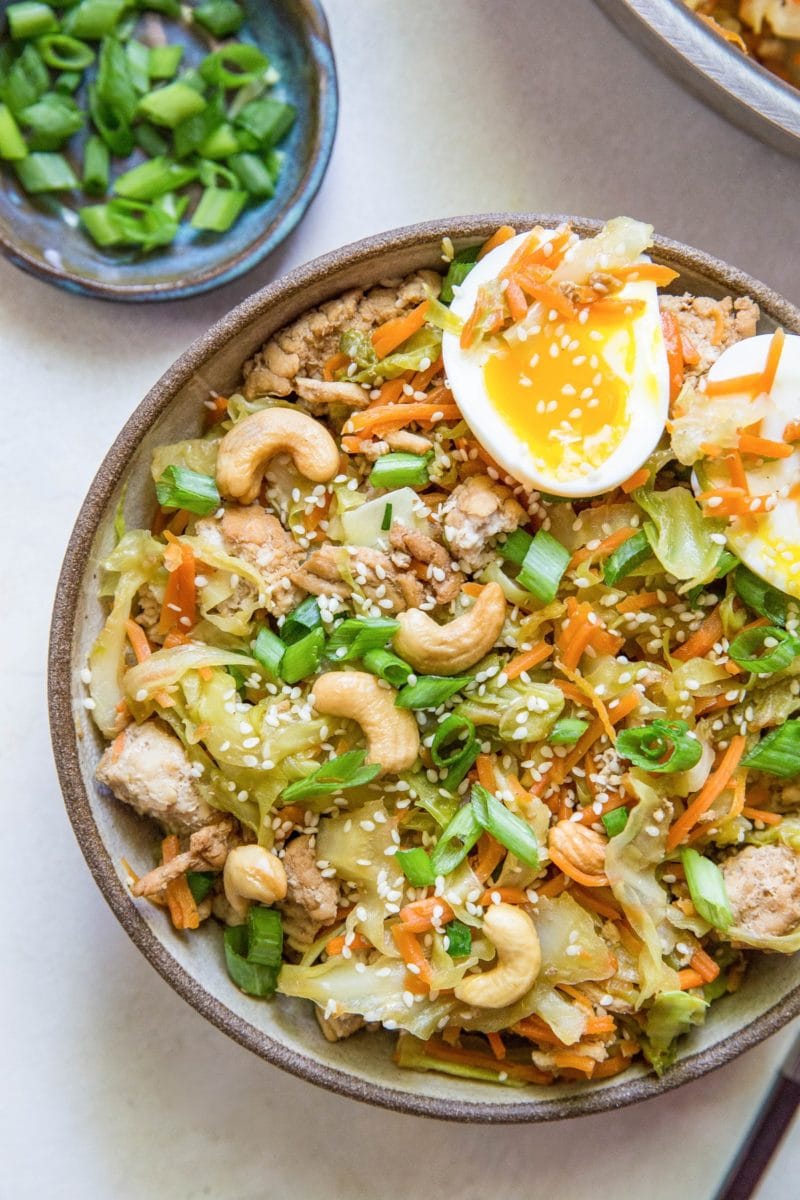 Close up top down image of a ground turkey egg roll bowl with jammy eggs.