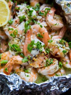 Lemon Garlic Foil Packet Shrimp with melted butter and fresh garlic inside a packet of aluminum foil. Fresh out of the oven, ready to serve.