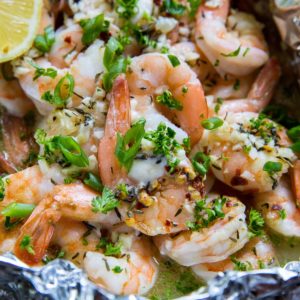 Lemon Garlic Foil Packet Shrimp with melted butter and fresh garlic inside a packet of aluminum foil. Fresh out of the oven, ready to serve.