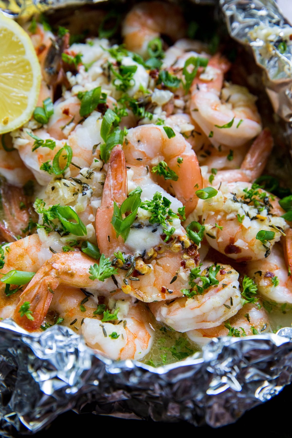 Lemon Garlic Foil Packet Shrimp with melted butter and fresh garlic inside a packet of aluminum foil. Fresh out of the oven, ready to serve.