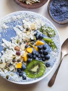 Tropical Blue Smoothie Bowl with mango, coconut, kiwi, and blueberries. Make a blue smoothie bowl with blue spirulina or blue pea powder for a healthy antioxidant packed breakfast | TheRoastedRoot.net