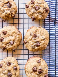 Chocolate chip cookies sitting on a wire rack to cool.