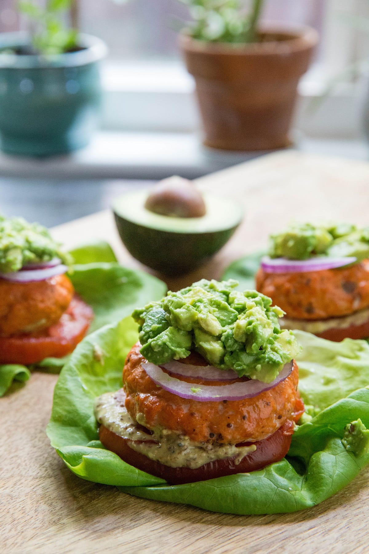 Baked salmon burgers on a lettuce bun with toppings