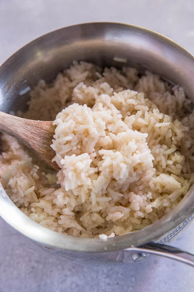 saucepan of coconut rice with a wooden spoon
