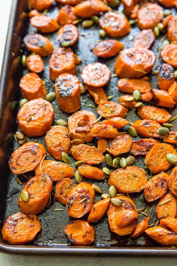 roasted carrots on a baking sheet with pumpkin seeds
