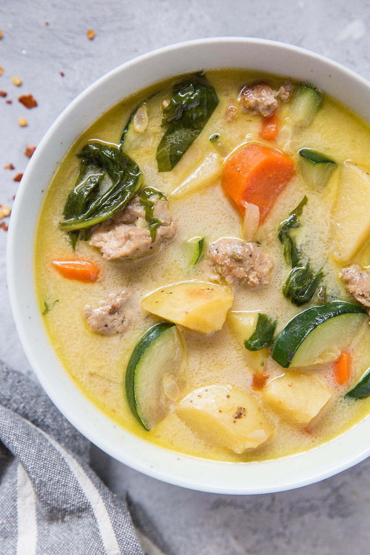 top down photo of hearty ground turkey soup with napkin and garlic