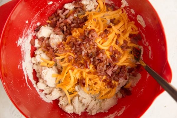 Cheddar cheese and bacon in the mixing bowl with the biscuit dough