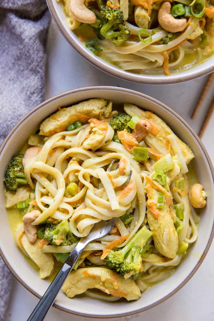 Close up top down shot of bowl of curry noodles with napkin