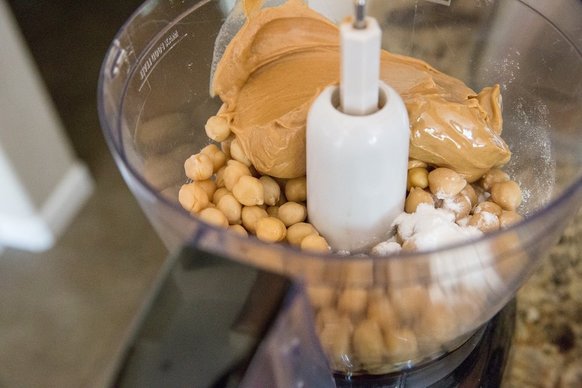 Food processor with chickpeas, peanut butter, and baking powder, ready to make cookie dough.