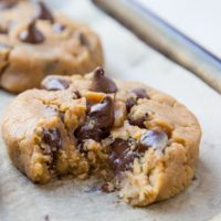 Close up of a peanut butter chocolate chip cookie with a bite taken out with gooey chocolate visible.