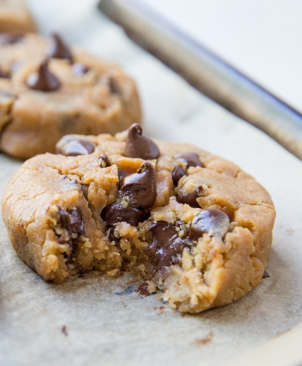 Close up of a peanut butter chocolate chip cookie with a bite taken out with gooey chocolate visible.