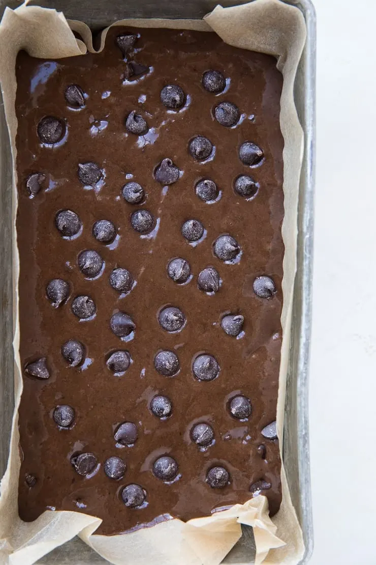 Black bean banana bread batter in a loaf pan with chocolate chips sprinkled on top