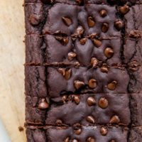 Top down photo of chocolate black bean banana bread on parchment paper with slices cut