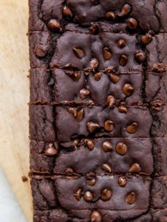 Top down photo of chocolate black bean banana bread on parchment paper with slices cut