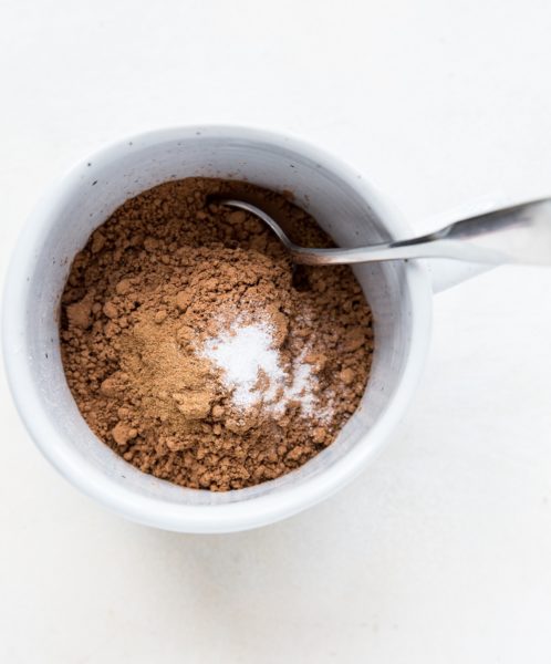 flour, cocoa powder, sea salt and cinnamon in a mug.