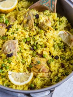 Aromatic Saffron Chicken with Coconut Rice in a large skillet with slices of lemon