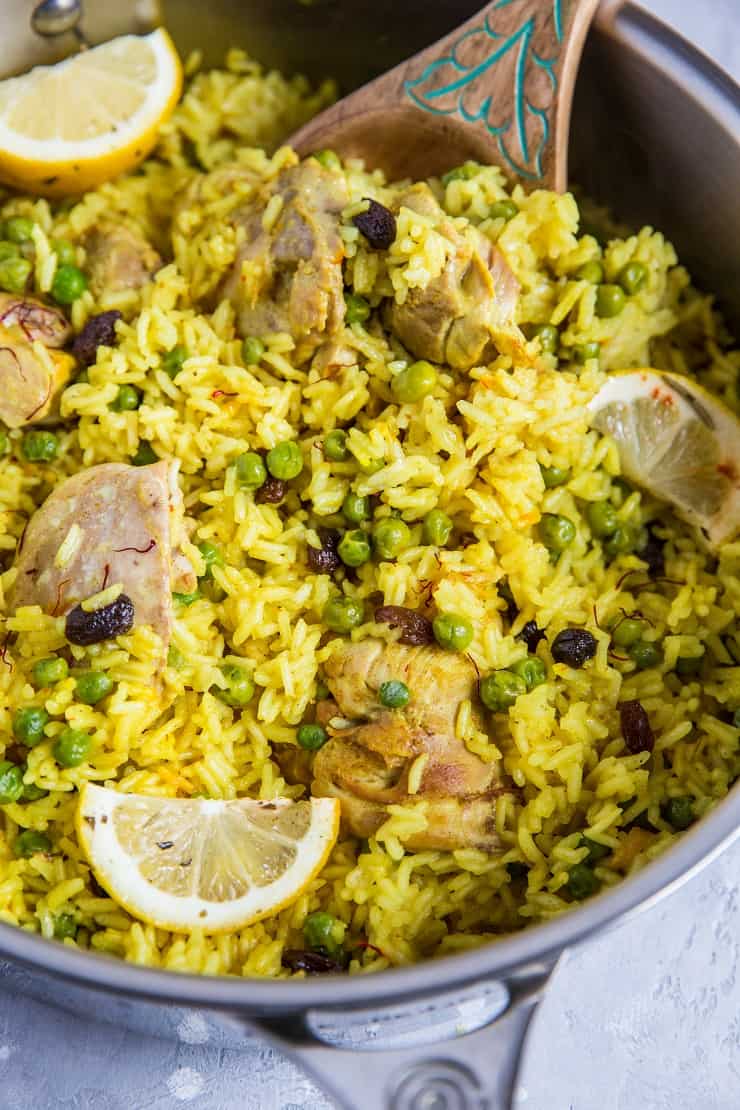 Aromatic Saffron Chicken with Coconut Rice in a large skillet with slices of lemon